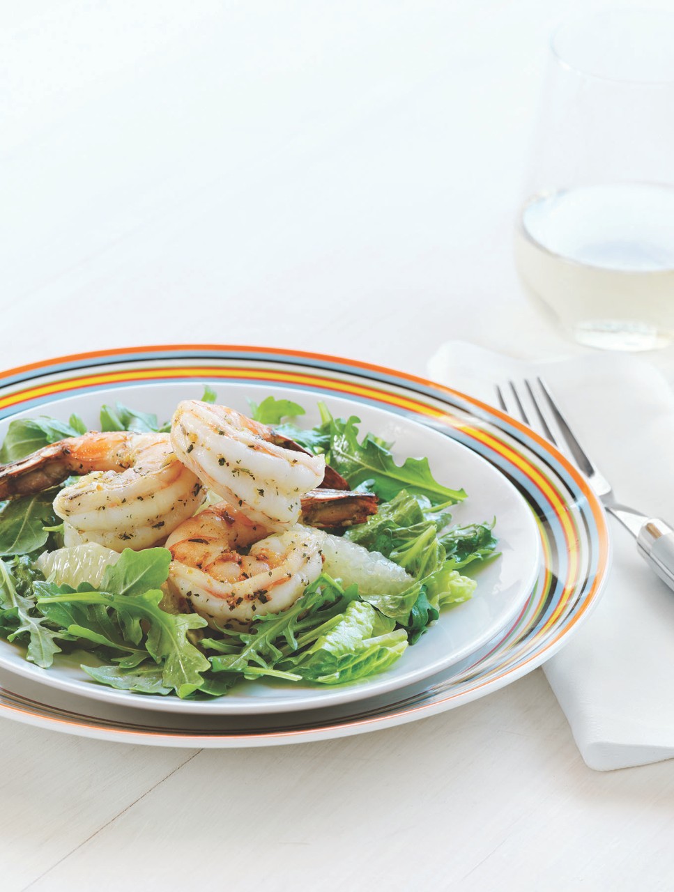 Salade de roquette arrosée de vinaigrette au pamplemousse avec crevettes épicées