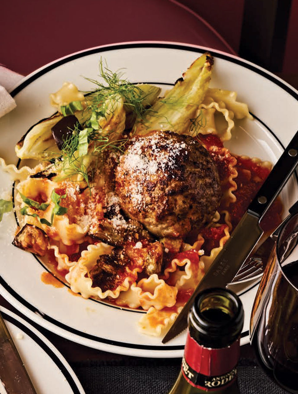 Boulettes de viande géantes farcies aux olives servies avec pâtes, fenouil et aubergine