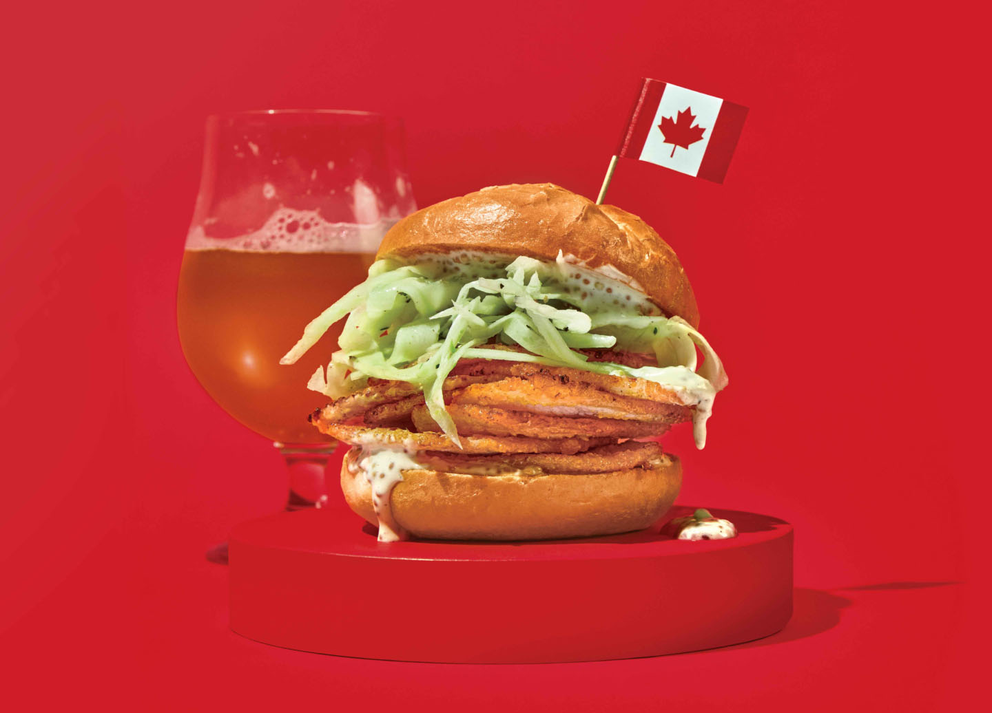 Sandwich au bacon de dos avec salade de fenouil et de pommes piqué d’un cure-dent décoré du drapeau canadien